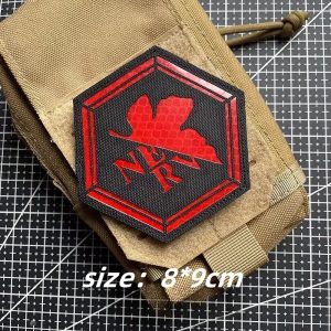 Patch hexagonal com o logotipo da NERV, de Evangelion, em preto e vermelho, numa bolsa bege