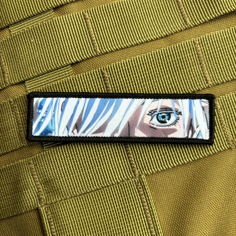Patch alongado com o olho azul do Gojo Satoru, de Jujutsu Kaisen, num colete verde