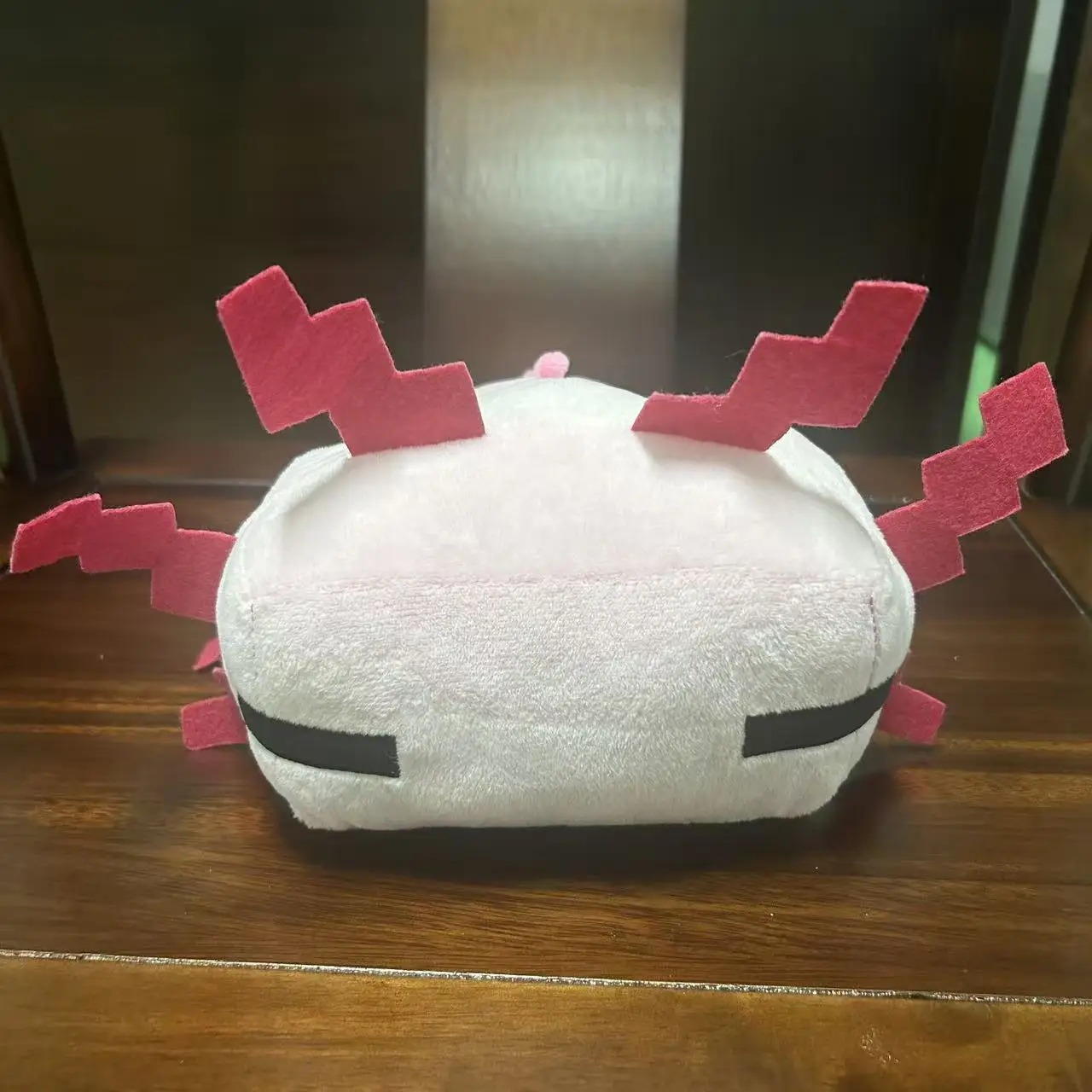 Axolote rosa de Minecraft em pelúcia, de frente, com o rosto de traços simples