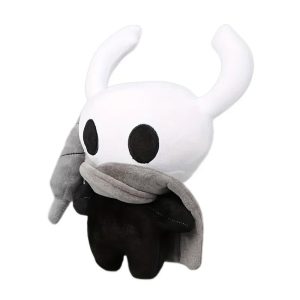 Pelúcia do Cavaleiro de Hollow Knight, de cabeça branca com chifres, corpo preto e capa cinza