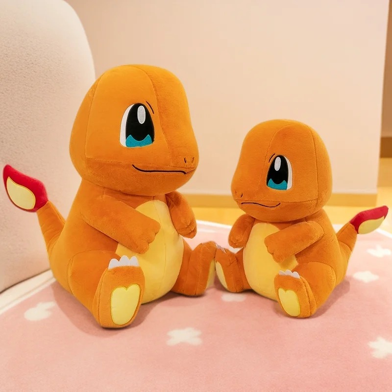 Duas pelúcias do Charmander de tamanhos diferentes, lado a lado