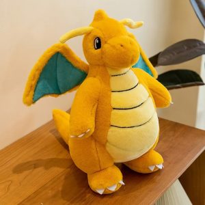 Dragonite de Pokémon em pelúcia, sentado numa mesa de madeira, de frente