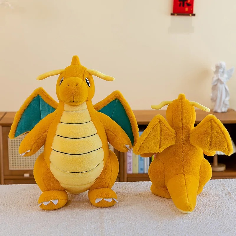 Duas pelúcias do Dragonite, uma de frente e outra de costas, numa mesa