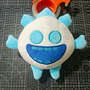 Espírito de Gelo de Clash Royale em pelúcia branca e azul, com sorriso largo, fotografado de cima