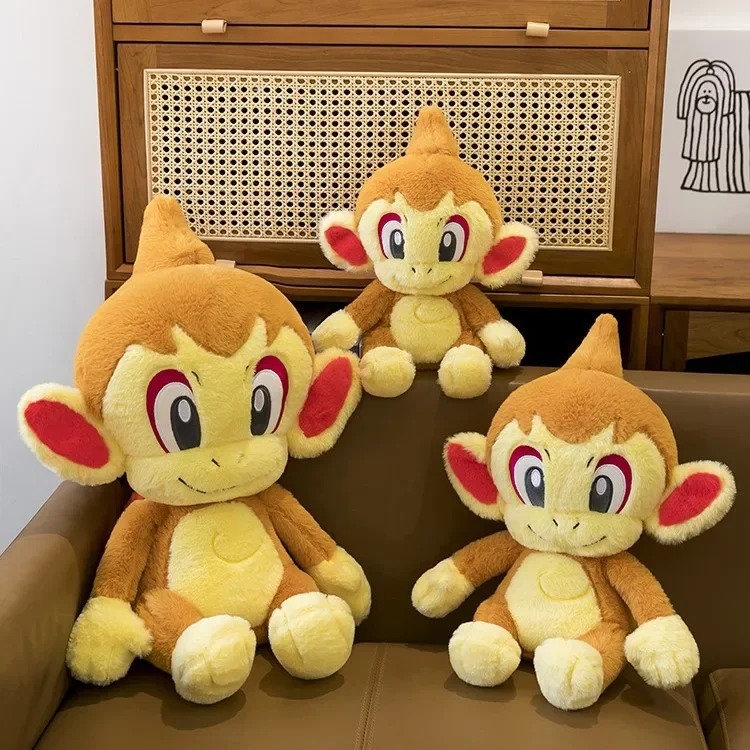 Trio de pelúcias do Chimchar, de Pokémon, em tamanhos diferentes, sobre um sofá
