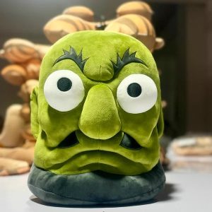 Kashira de pelúcia, cabeça verde de A Viagem de Chihiro, de olhos grandes e sobrancelhas franzidas