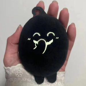 Krobus, de Stardew Valley, em pelúcia preta de rosto bordado sorrindo, na palma da mão