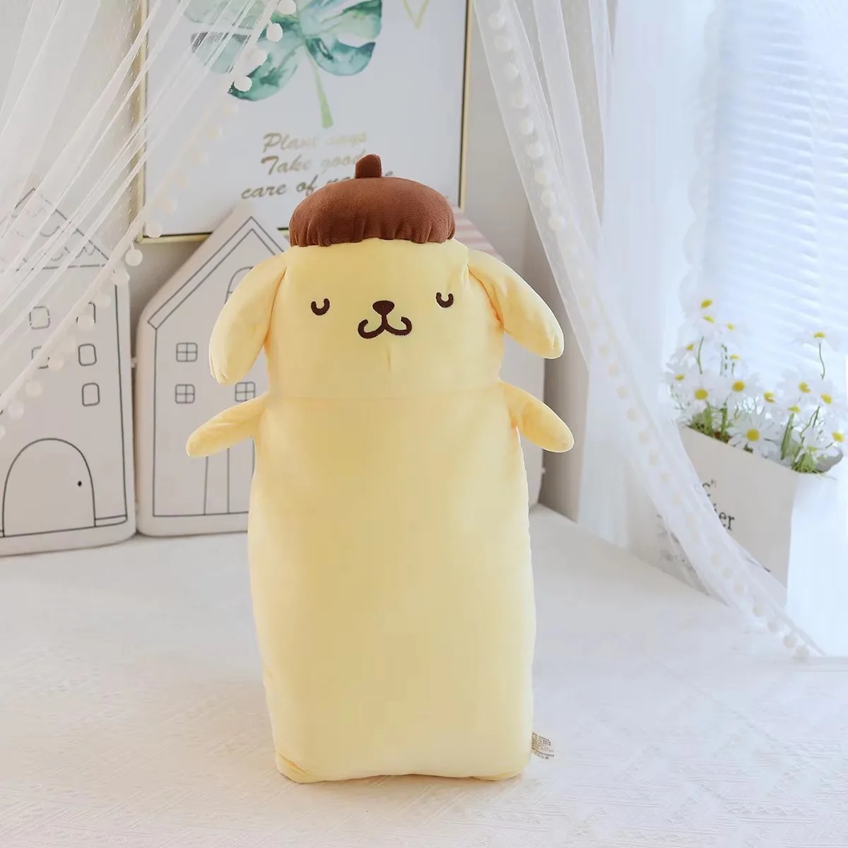 Pelúcia longa do Pompompurin de olhos fechados, em pé diante de uma cortina