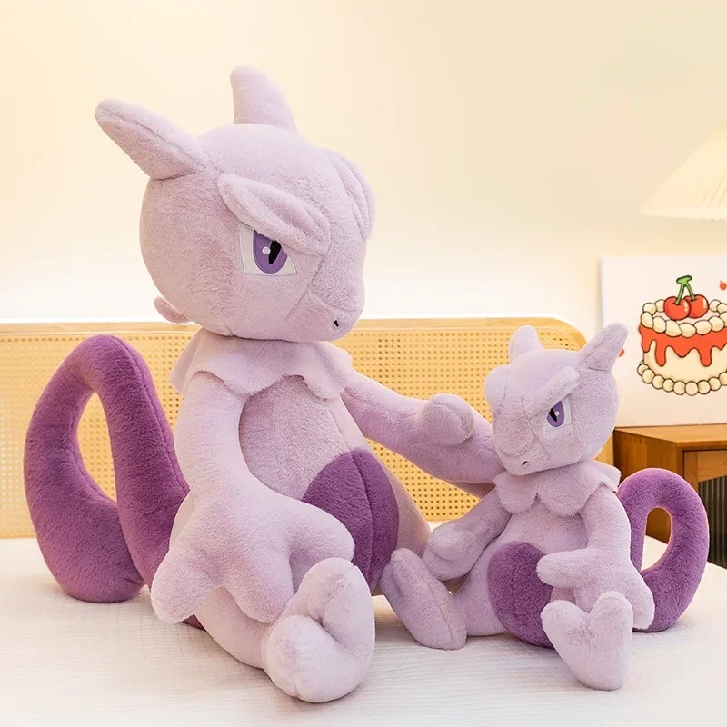 Duas pelúcias do Mewtwo de tamanhos diferentes numa cama, com a cauda roxa curvada