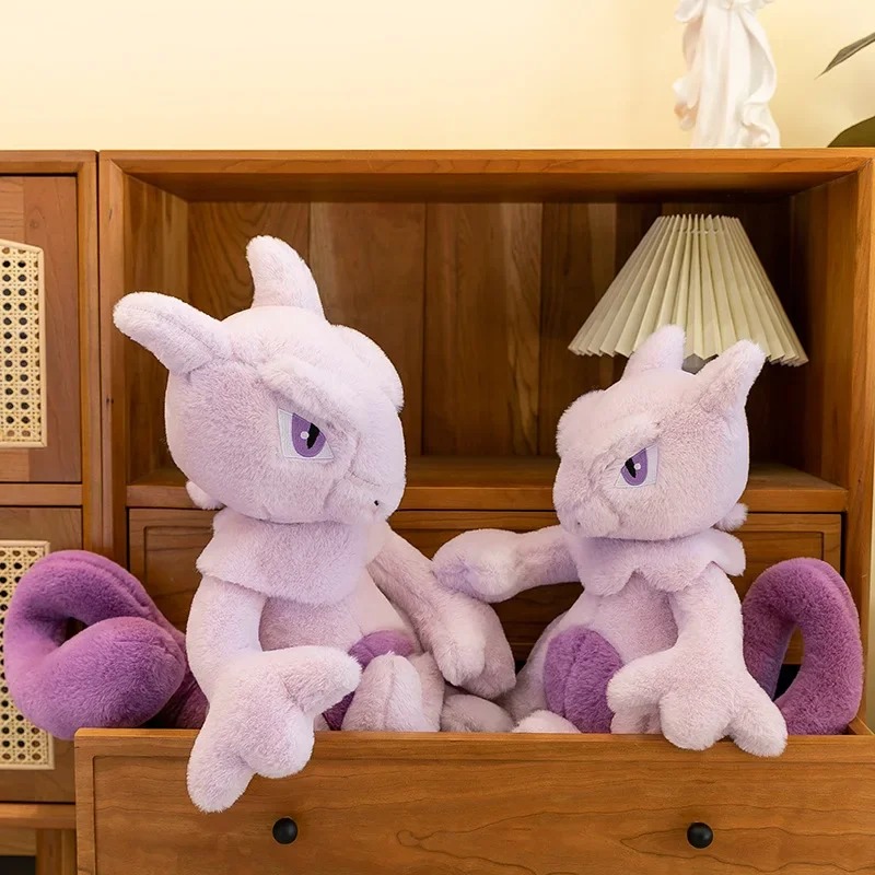 Duas pelúcias do Mewtwo numa estante de madeira