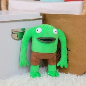 Mr. Frog de Smiling Friends em pelúcia, sapo verde de olhos grandes e short marrom, sobre pelo branco