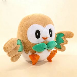 Rowlet de pelúcia, de Pokémon, de frente, com gravatinha de folhas verdes e pés laranja