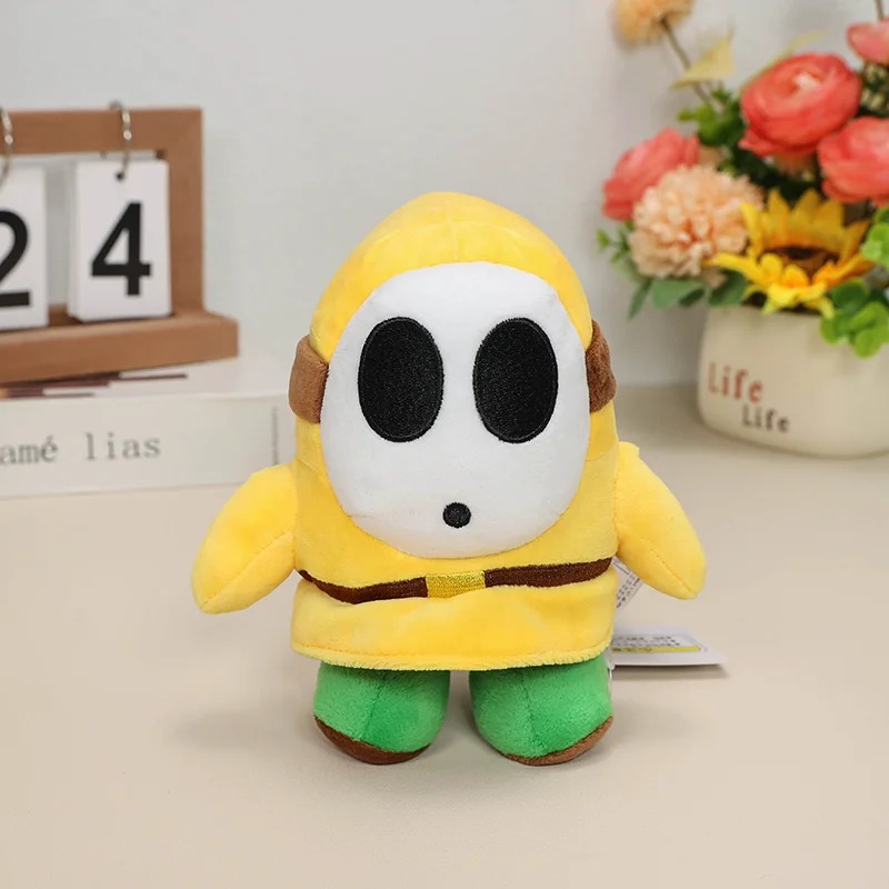 Shy Guy amarelo de Super Mario em pelúcia, com pés verdes