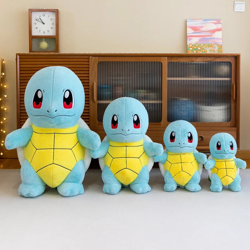 Quatro pelúcias do Squirtle de tamanhos diferentes lado a lado num móvel