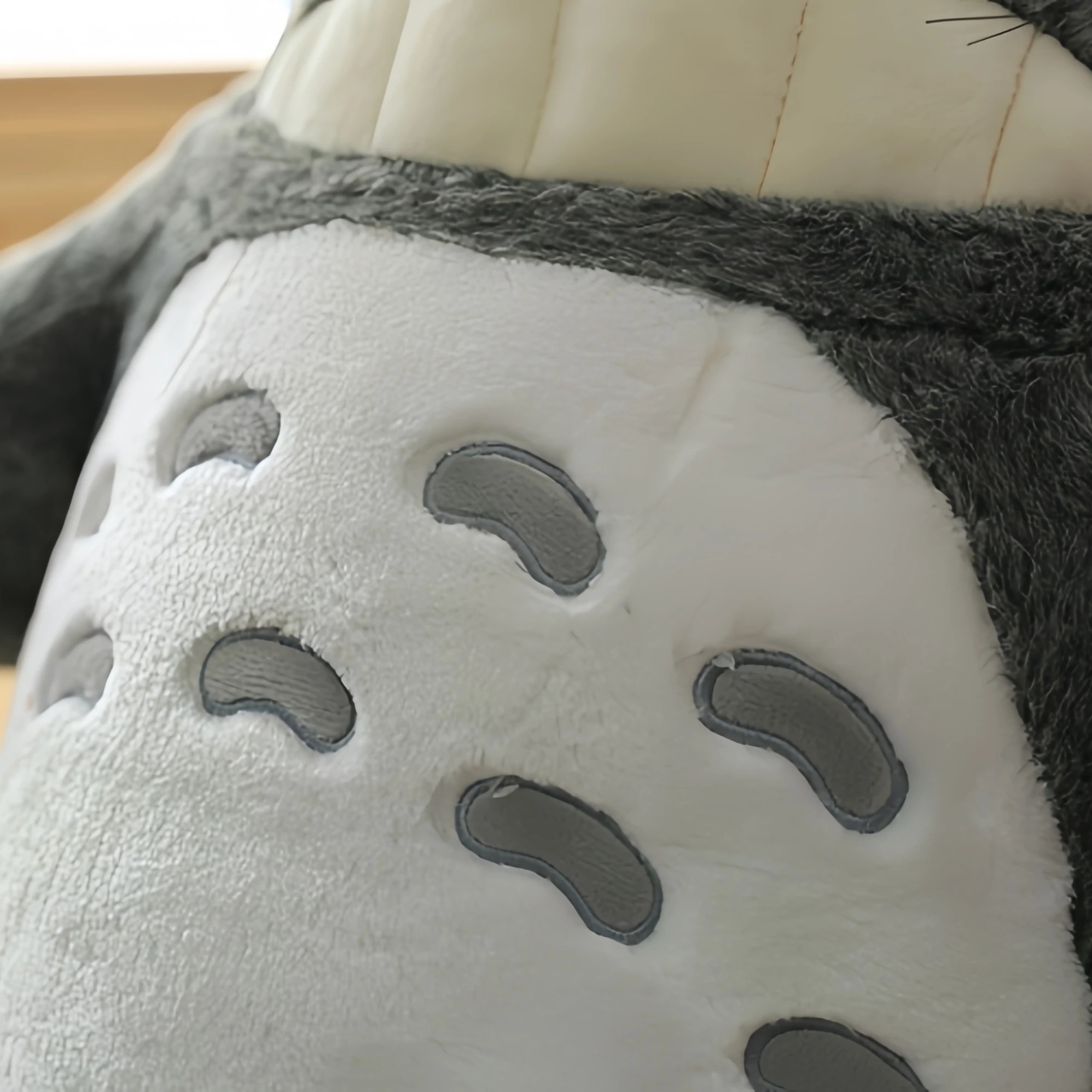 Detalhe da barriga da pelúcia do Totoro com as marcas em V bordadas