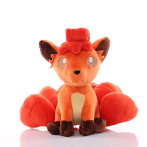 Vulpix laranja de pelúcia, de Pokémon, sentado, com as caudas vermelhas abertas atrás
