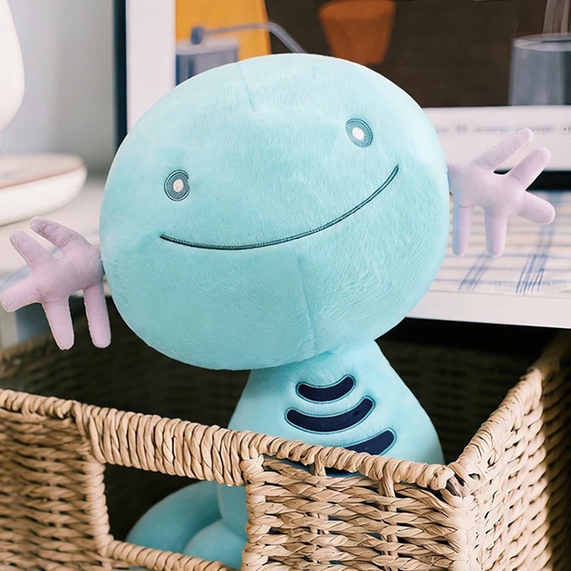 Wooper de pelúcia, de Pokémon, azul-turquesa, dentro de uma cesta de vime