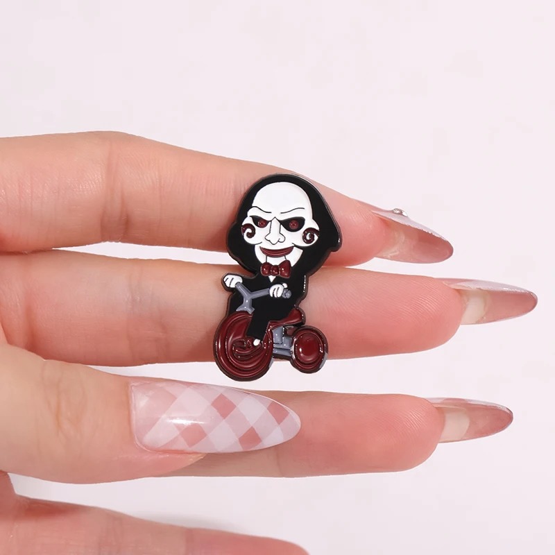 Pin do Billy de Jogos Mortais sobre as unhas de uma mão, mostrando o tamanho