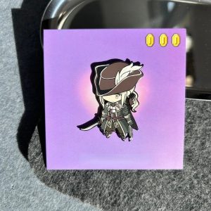 Pin esmaltado chibi de Bloodborne, com personagem de chapéu de abas largas, sobre cartela roxa