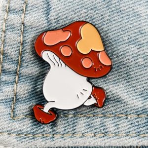 Pin do cogumelo andante de Dungeon Meshi, de chapéu vermelho com pintas, preso numa jaqueta jeans