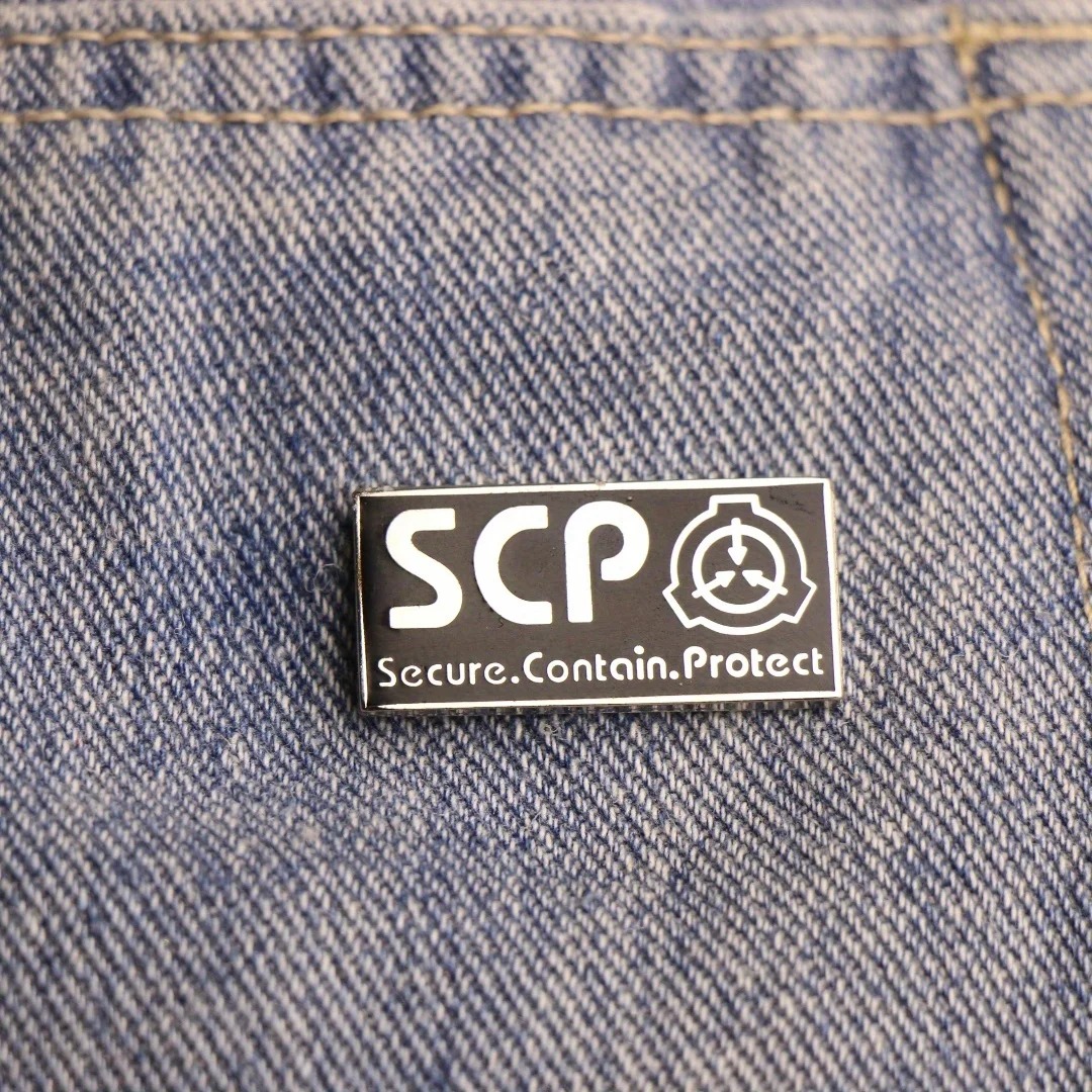 Pin esmaltado da SCP Foundation preso em tecido jeans