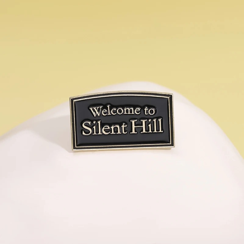 Pin Welcome to Silent Hill sobre tecido branco em fundo amarelo