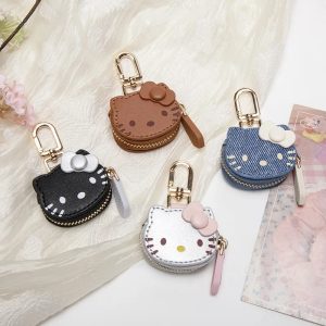 Quatro mini porta-moedas da Hello Kitty em marrom, preto, azul e prata sobre tecido branco