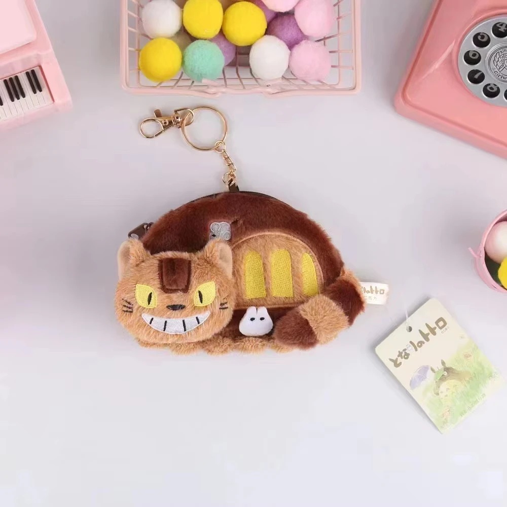 Porta-moedas de pelúcia do Gatobus, de Meu Amigo Totoro, com argola dourada sobre fundo rosa