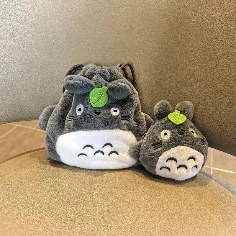 Dois porta-moedas de pelúcia do Totoro com folha verde na cabeça, um maior e outro menor