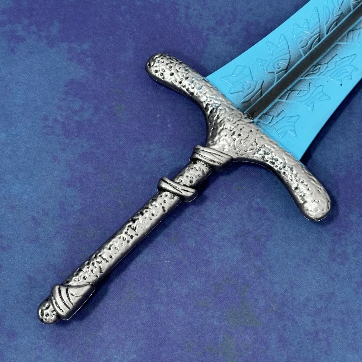 Guarda e cabo prateado trabalhado da Dark Moon Greatsword, de Elden Ring, em detalhe