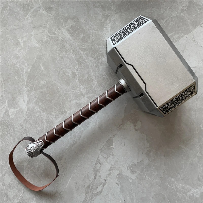 Martelo Mjölnir prateado com cabo enrolado e alça de couro sobre piso de mármore