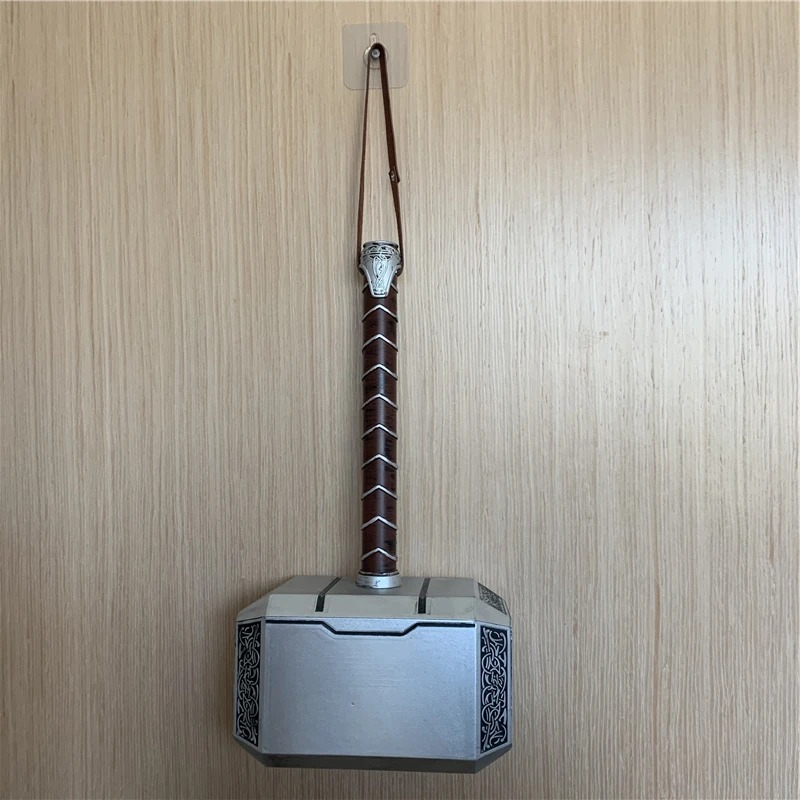 Mjölnir do Thor pendurado pela alça numa parede de madeira