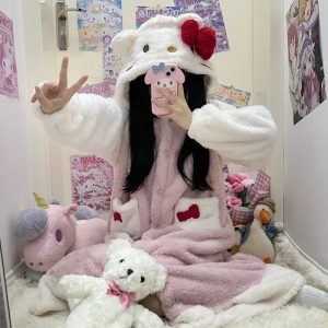 Roupão rosa e branco da Hello Kitty com capuz de orelhinhas e laço vermelho, usado em um quarto