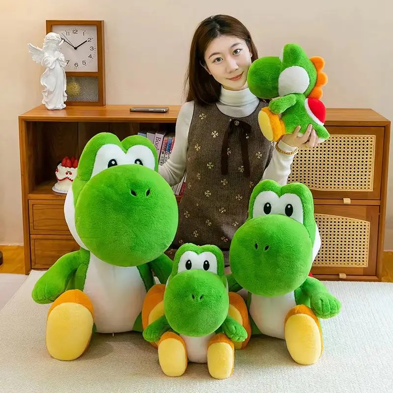 As quatro versões de tamanho do Yoshi de pelúcia ao lado de uma estante